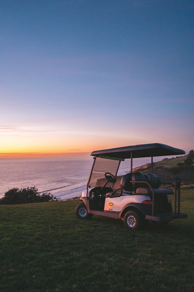 Golf cart on a golf course at sunset with warm golden light