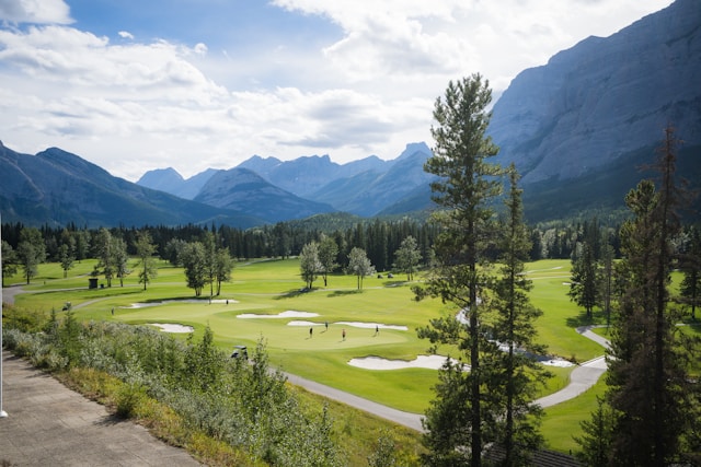 Golf course set in a vast natural landscape with mountains in the background and scenic surroundings